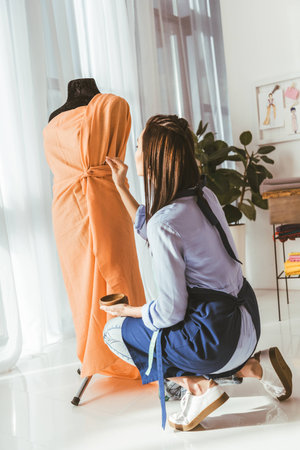 seamstress putting pin in dress on mannequinの写真素材