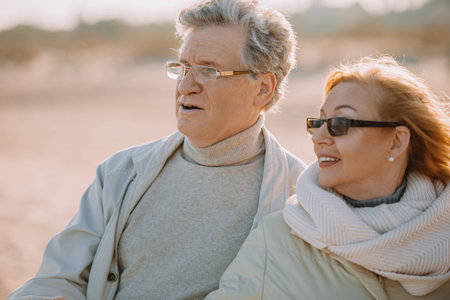 senior couple in eyeglasses hugging and looking somewhereの写真素材