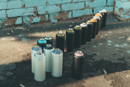 cans with aerosol paint standing in row on asphaltの写真素材