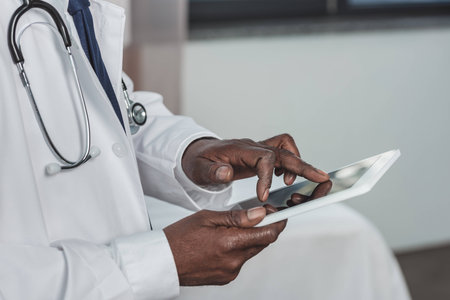 Cropped image of african american doctor searching something on a tabletの写真素材