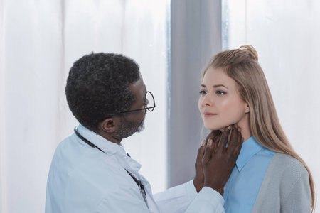 african american Doctor palpating female patient lymph nodesの写真素材