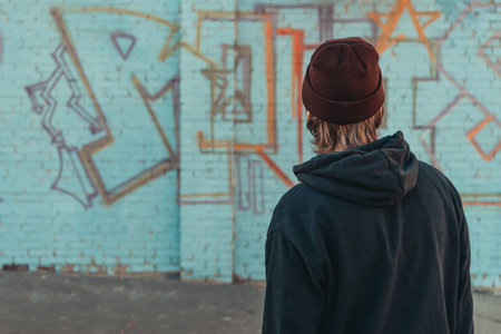 rear view of man looking at colorful graffiti on wall