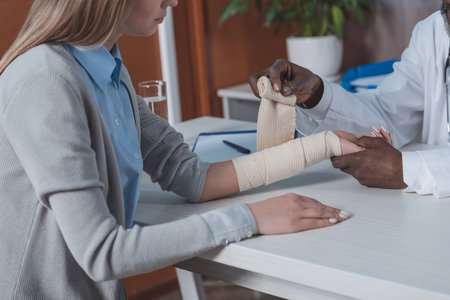 Cropped image of african american doctor bandaging patient handの写真素材