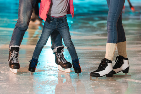 cropped shot of young family in skates skating together on rinkの写真素材