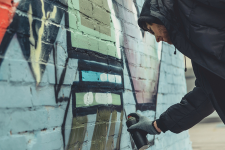 street artist painting colorful graffiti on wallの写真素材