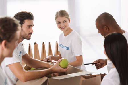 group of young multiethnic volunteers packing food for charity