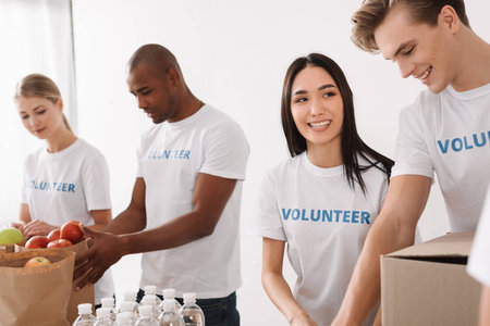 group of young multiethnic volunteers working together with charity goodsの写真素材