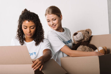 beautiful female volunteers packing toys for charity