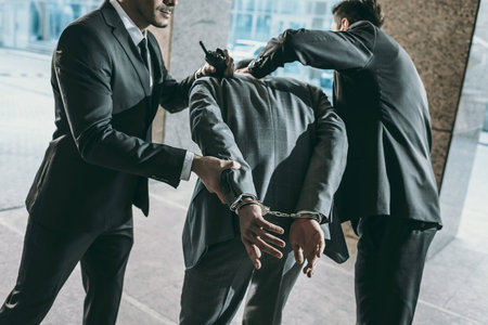 Cropped image of security guards arresting male offenderの写真素材
