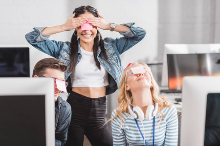 happy people with stickers on eyes in modern office