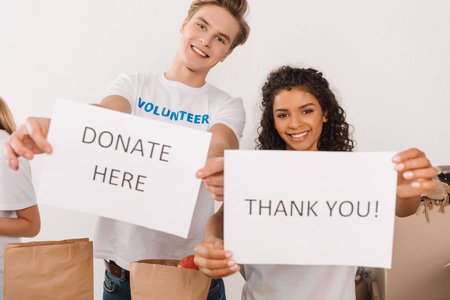 young multiethnic volunteers holding charity placardsの写真素材