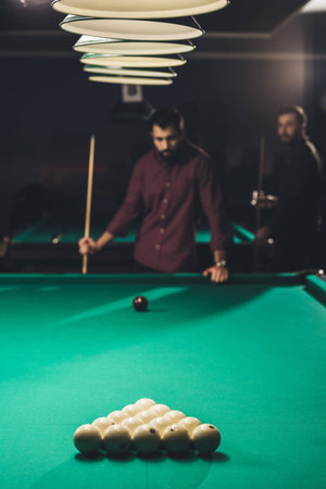 handsome men playing in russian pool at bar