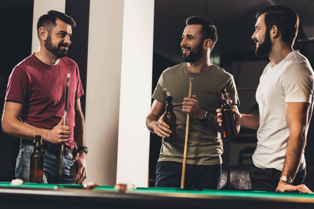 young handsome caucasian men beside billiard table in bar