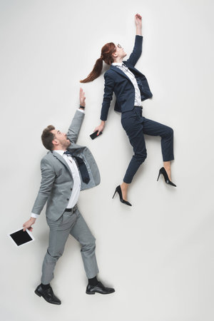 overhead view of businesspeople with tablet and smartphone in hands isolated on greyの写真素材