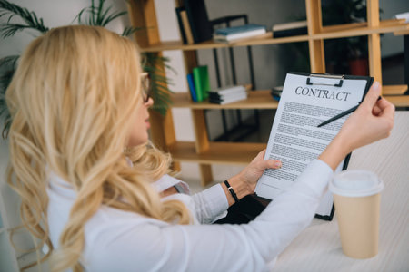 side view of businesswoman reading working contractの写真素材