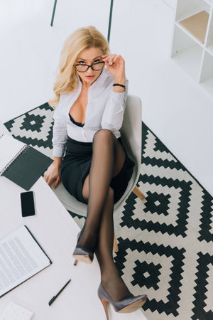 overhead view of sexy woman sitting in chair and looking at cameraの写真素材