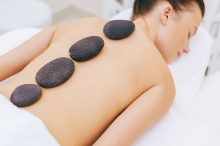 close-up shot of woman having stone therapy at spa salonの写真素材