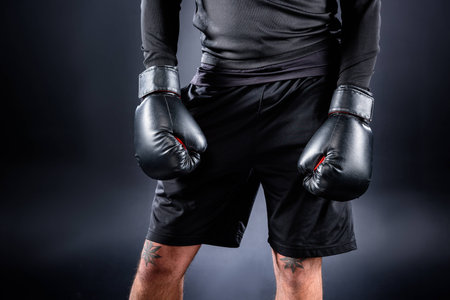 cropped shot of boxer in black gloves on blackの写真素材