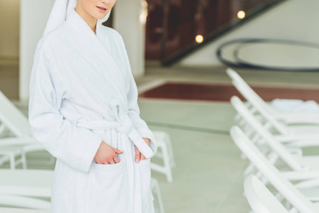 cropped shot of young woman in bathrobe at spa salon
