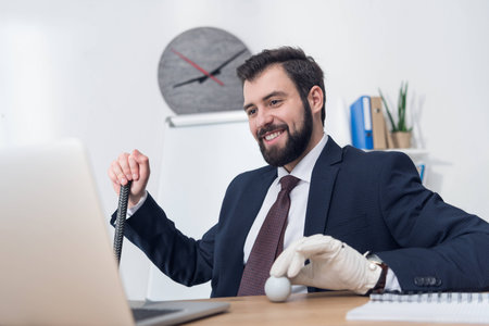 smiling businessman with golf equipment at workplace in officeの写真素材