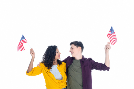 embracing teenage students with american flags isolated on whiteの写真素材