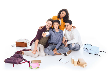 multicultural students taking selfie together isolated on whiteの写真素材