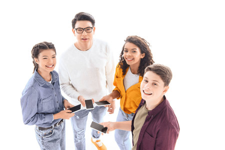 high angle view of multicultural teen friends with smartphones isolated on whiteの写真素材