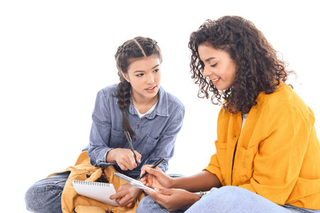 portrait of multiethnic students doing homework together isolated on whiteの写真素材