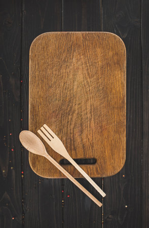 Top view of cutting board and wooden utensils on tableの写真素材