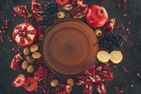 Top view of empty plate among fruits on a tableの写真素材
