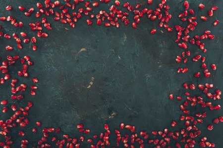 Top view of pomegranate seeds on a gray shabby surfaceの写真素材