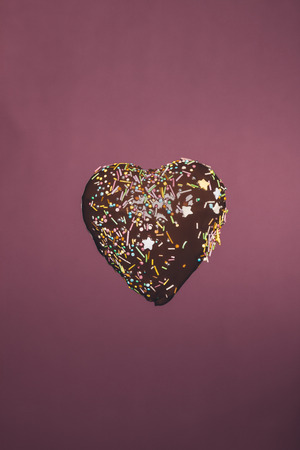 chocolate heart shaped candy with glaze isolated on pink