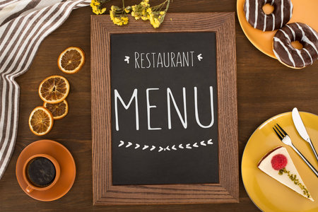 top view of restaurant menu and pastries with coffee on wooden tableの写真素材