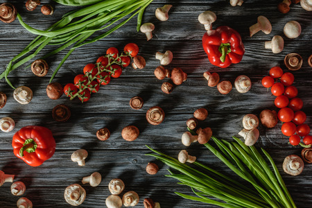 top view of various raw vegetables and mushrooms on wooden tabletopの写真素材