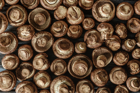 full frame shot of raw champignon mushrooms on wooden surfaceの写真素材