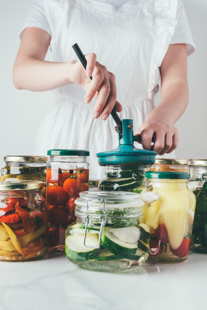 cropped image of woman preparing preserved vegetables on table at kitchenの写真素材