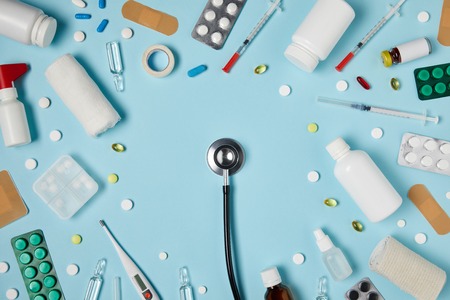 top view of stethoscope surrounded with various medicines on blue surfaceの写真素材