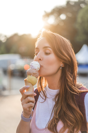 close up view of young woman eating ice creamの写真素材