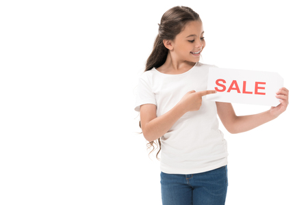portrait of smiling kid pointing at sale banner in hand isolated on whiteの写真素材