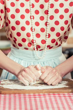 cropped shot of woman kneading dough with handsの写真素材
