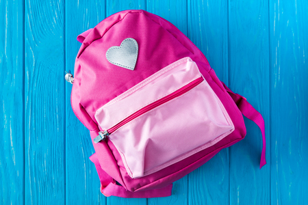 top view of pink backpack on blue wooden backgroundの写真素材