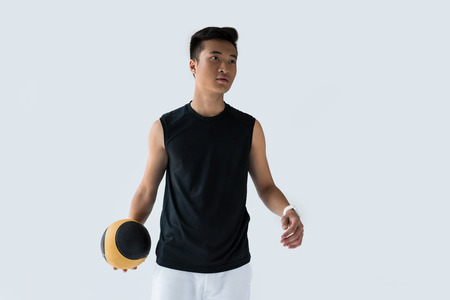 young asian sportsman with medicine ball isolated on grey background