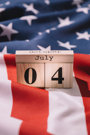 close up view of wooden calendar with 4th july date on american flag, americas independence day conceptの写真素材