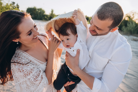 happy family with baby boy on beachの写真素材