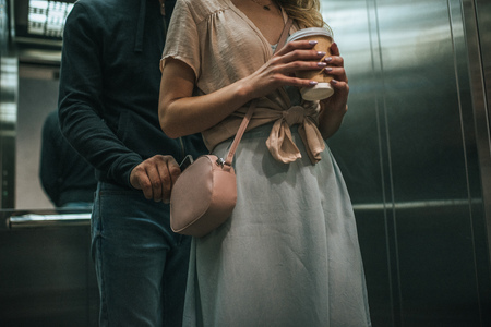 cropped view of robbery pickpocketing smartphone from womans bag in elevatorの写真素材