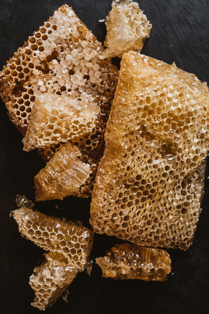elevated view of honeycombs on black tableの写真素材