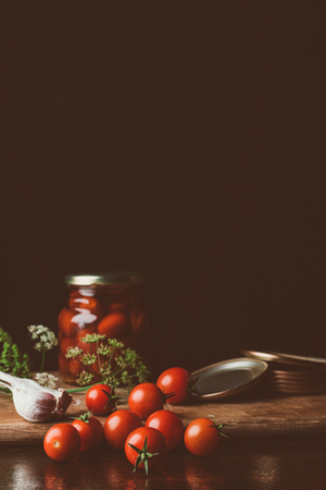 preserved tomatoes and fresh tomatoes on kitchen tableの写真素材