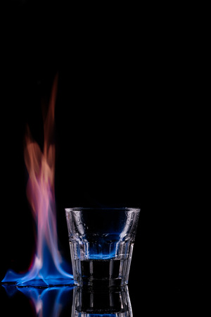 close up view of glass of burning sambuca drink on black backgroundの写真素材