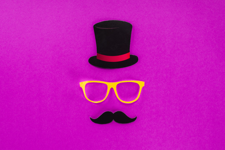 top view of gentleman face made of cardboard eyeglasses, mustache and hat on pink surfaceの写真素材