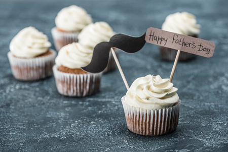 creamy cupcakes with mustache sign and Happy fathers day inscription on concrete surfaceの写真素材